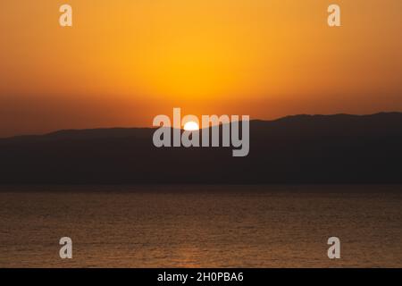 Sunrise in red and yellow over the mountains of the Dead Sea - Israel Stock Photo