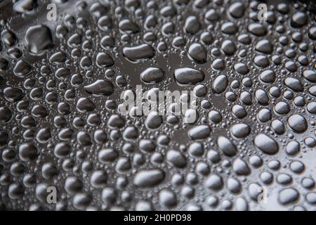 Water droplets rain drops on a silver metal tray Stock Photo