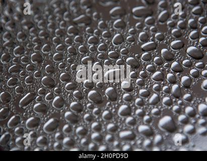 Water droplets rain drops on a silver metal tray Stock Photo