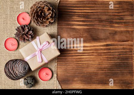Christmas Flatlay of pine cones, candles and gift boxes on wooden background with copy space Stock Photo