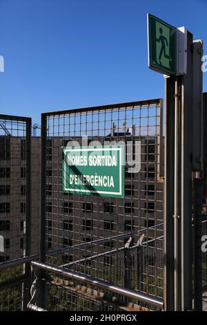 Emergency exit fire escape in a public building in Barcelona, Catalonia region of Spain. Catalan language emergency exit sign. Stock Photo