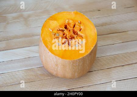 Cut pumpkin on wooden background, half pumpkin Stock Photo