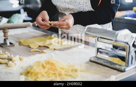 Woman prepare fresh ravioli inside pasta factory - Focus on hands Stock Photo