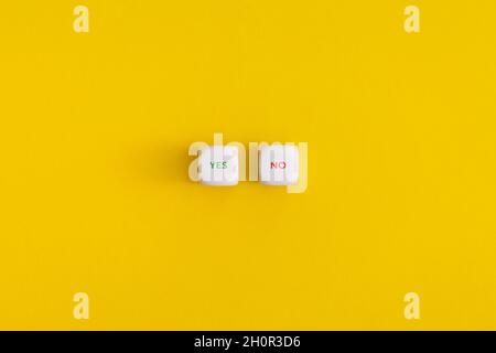 Yes and NO on a white cubes on yellow background. Approving, voting or right decision concept. Stock Photo