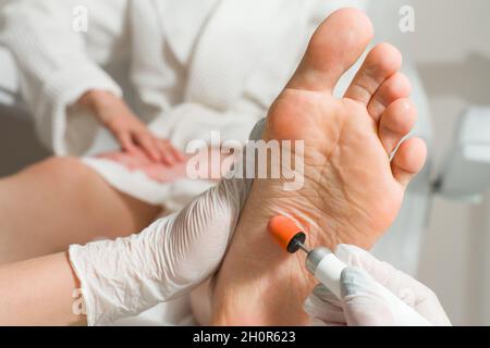 Podiatrist doctor, performs the procedure of treating a woman's legs. Cosmetic procedures of the feet Stock Photo