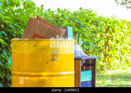 Garbage cans for collecting sorting all kinds of rubbish placed in city park. Stock Photo