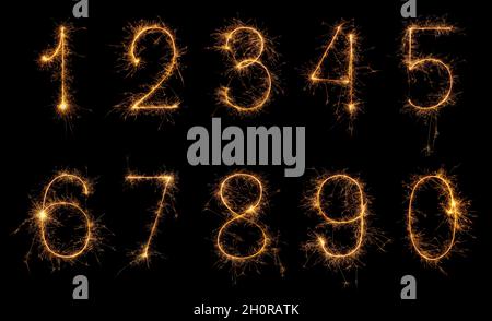 Set of burning sparkler numbers from 0 to 9 made of bengal fire, sparkler fireworks candle isolated on a black background. Party dark backdrop. Stock Photo