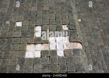 Missing tiles in a grey mosaic abandoned swimming pool Stock Photo