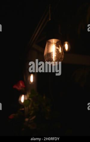 A series of four garden lights glowing in the dark. Stock Photo