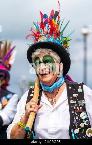 Close up head and shoulders of mature woman morris dancer wearing a hot hat decorated with feathers. From the Whitstable Dead Horse Morris side. Stock Photo