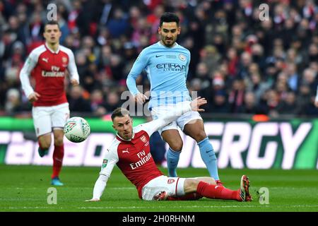 Manchester City's Ilkay Gundogan is tackled by Arsenal's Aaron Ramsey Stock Photo