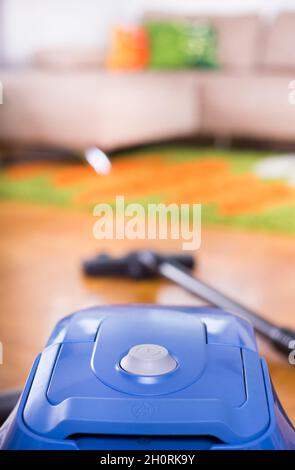 Close up of turn on button of vacuum cleaner on floor of living room Stock Photo