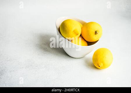 Bowl of fresh lemons on a table Stock Photo