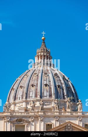 The detailed view of dome summit of Papal Basilica of St. Peter in the Vatican against blue sky and copy space. Rome, Italy Stock Photo