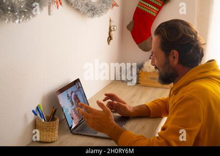 Mature man smile and calling cheerful woman to celebrate christmas together using video call conference application on laptop computer with wireless i Stock Photo