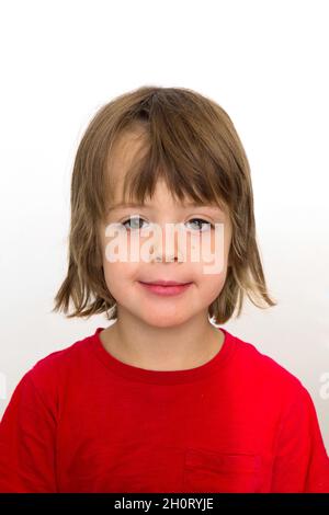 5 five years old photo for passport or ID card. Emotionally grimacing little boy with blond hair and bright green eyes white background Stock Photo