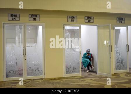 Bali, Indonesia. 14th Oct, 2021. A health worker is seen waiting at a swab test room at Ngurah Rai International Airport in Bali, Indonesia, Oct. 14, 2021. International visitors from 19 countries with a COVID-19 positivity rate of less than five percent have been allowed to come to Indonesia, Coordinating Minister for Maritime and Investment Affairs Luhut Binsar Pandjaitan said at a meeting in Jakarta on Wednesday. Credit: Bisinglasi/Xinhua/Alamy Live News Stock Photo