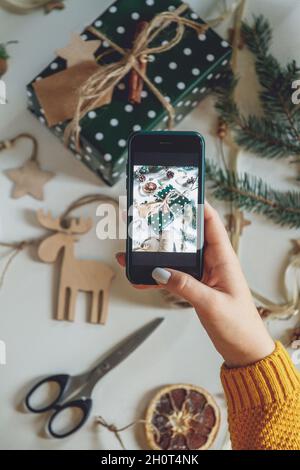 Female hands take photo with mobile phone of christmas decoratio Stock Photo