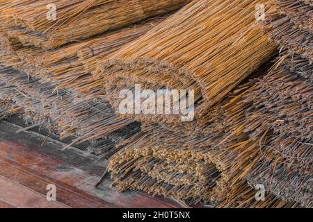 Straw rope dry reed natural material is stored in rolls. Stock Photo
