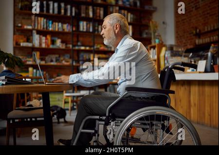 Adult disabled man using laptop, top view Stock Photo