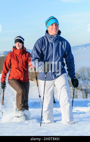 Happy couple doing snowshoe tour in wintry nature iin bavaria Stock Photo