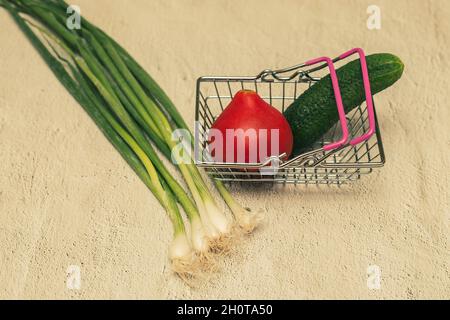 Vegetables in a small shopping basket: cucumber, tomato and zucchini. Stock Photo