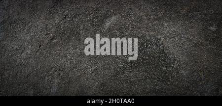 Black rough concrete surface, dark scary background, grunge texture. Stock Photo