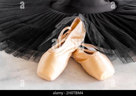 White ballet tutu skirt and beige pointe shoes with ribbon Stock Photo