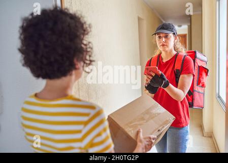 Delivery woman using mobile phone to confirm delivery Stock Photo
