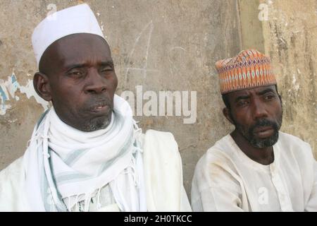 Men living in Shinkafi, a town in Zamfara state in northern Nigeria. Most of the people who live her are poor, living below US$1 a day. Hausa is spoken as the first language of the state, which is also the first state to have introduced Muslim sharia law. 'Farming is our pride' is the slogan of the state, which is largely agricultural. April 12, 2008. Stock Photo