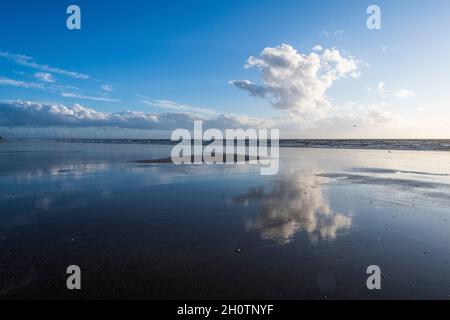 single big white cloud reflects in the ocean Stock Photo