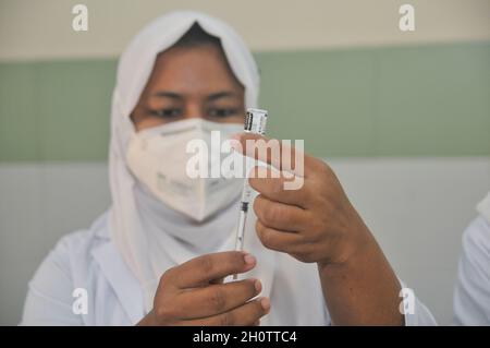 Sylhet, Bangladesh. 14th Oct, 2021. Medical staff prepare the 1st dose of the Pfizer-BioNTech Covid-19 Vaccine at the M A G Osmani medical college & hospital vaccination center. Credit: Majority World CIC/Alamy Live News Stock Photo