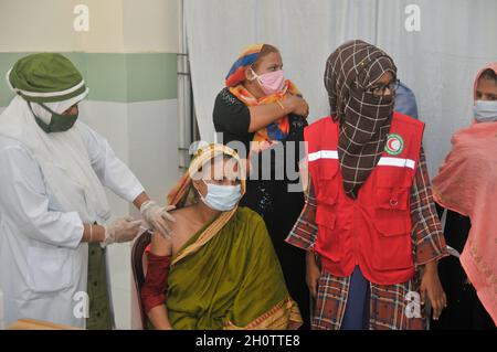 Sylhet, Bangladesh. 14th Oct, 2021. Medical staff administer the 1st dose of the Pfizer-BioNTech Covid-19 Vaccine at the M A G Osmani medical college & hospital vaccination center. Credit: Majority World CIC/Alamy Live News Stock Photo