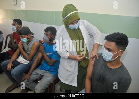 Sylhet, Bangladesh. 14th Oct, 2021. Medical staff administer the 1st dose of the Pfizer-BioNTech Covid-19 Vaccine at the M A G Osmani medical college & hospital vaccination center. Credit: Majority World CIC/Alamy Live News Stock Photo