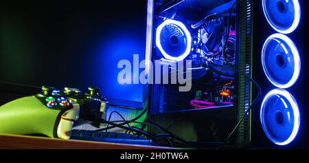 Game controller on a wooden desk by a pc rgb case Stock Photo