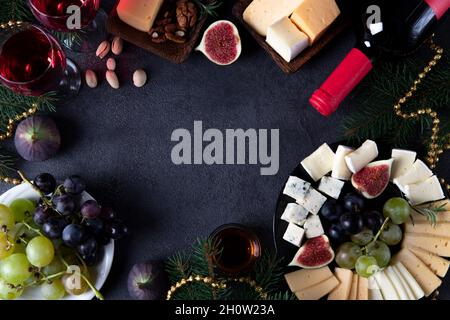 Frame made from varieties of cheese, fruits and nuts on dark background. New Year's Eve Party Snack Stock Photo