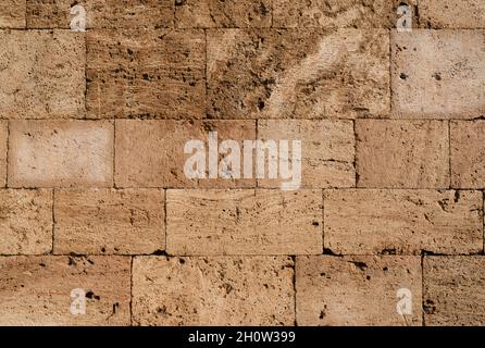 horizontal front view of ancient brown stone wall made of brown construction blocks Stock Photo