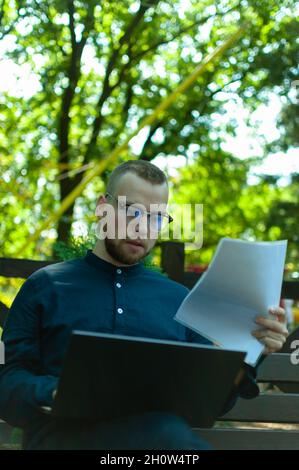 Ukrainian man in glasses working with a laptop and papers Stock Photo