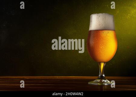 Glass of light beer on a wooden table. Dark background. Drink concept. Stock Photo