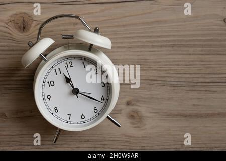 small white retro alarm clock on wood background with copy space Stock Photo