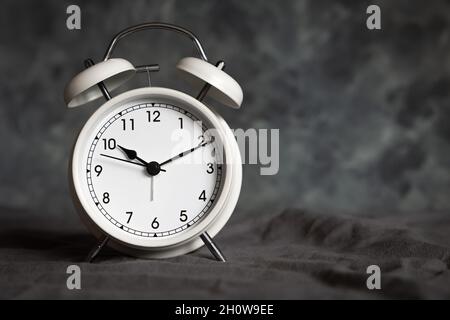 small white retro alarm clock on a grey background with copy space Stock Photo