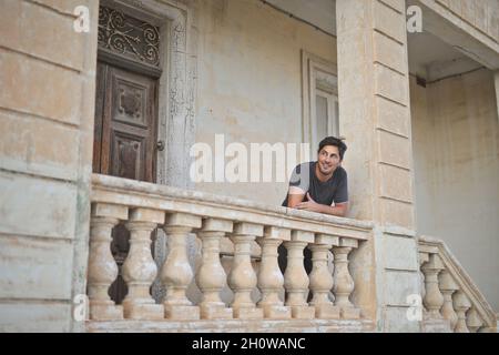 portrait of young man waiting for someone on the entrance of the house Stock Photo