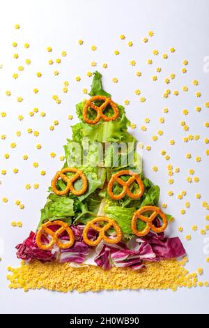 Christmas tree made from green salad products, cabbage, raw pasta and breadcrumbs. View from above Stock Photo