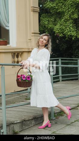Girl in a white dress with a basket. Stock Photo