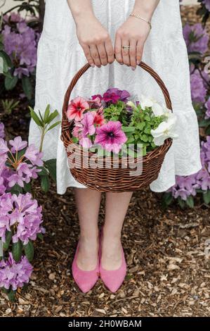 A basket of flowers and a white dress. Stock Photo