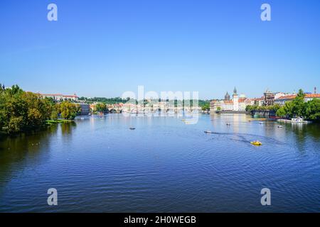 Prague Czech Republic - August 30 2017; Urban river landscape with small craft and people in distance enjoying summer day from Palacky Bridge. Stock Photo