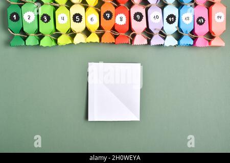 DO IT YOURSELF. Advent calendars made of colored paper in the shape of sweets. Step-by-step instructions. Step 5. Bend a small strip for further gluin Stock Photo