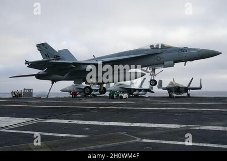 Naval flight operations take place aboard a aircraft carrier featuring F/A-18 Super Hornets and F-35C Joint Strike Fighter Stock Photo