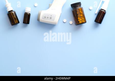 Flat lay medical equipment, pills, spray, nasal drops on pastel blue background. Covid-19, coronavirus treatment concept Stock Photo