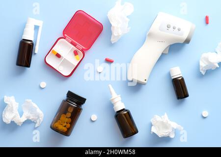 Flat lay different medical equipment, pills, sprayers, napkins on pastel blue background. Coronavirus, Covid-19 treatment concept. Stock Photo